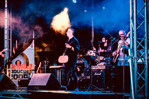 band, calm, concert, drummer, guitarist, motion, musicians, singer, stage, texture, warm light